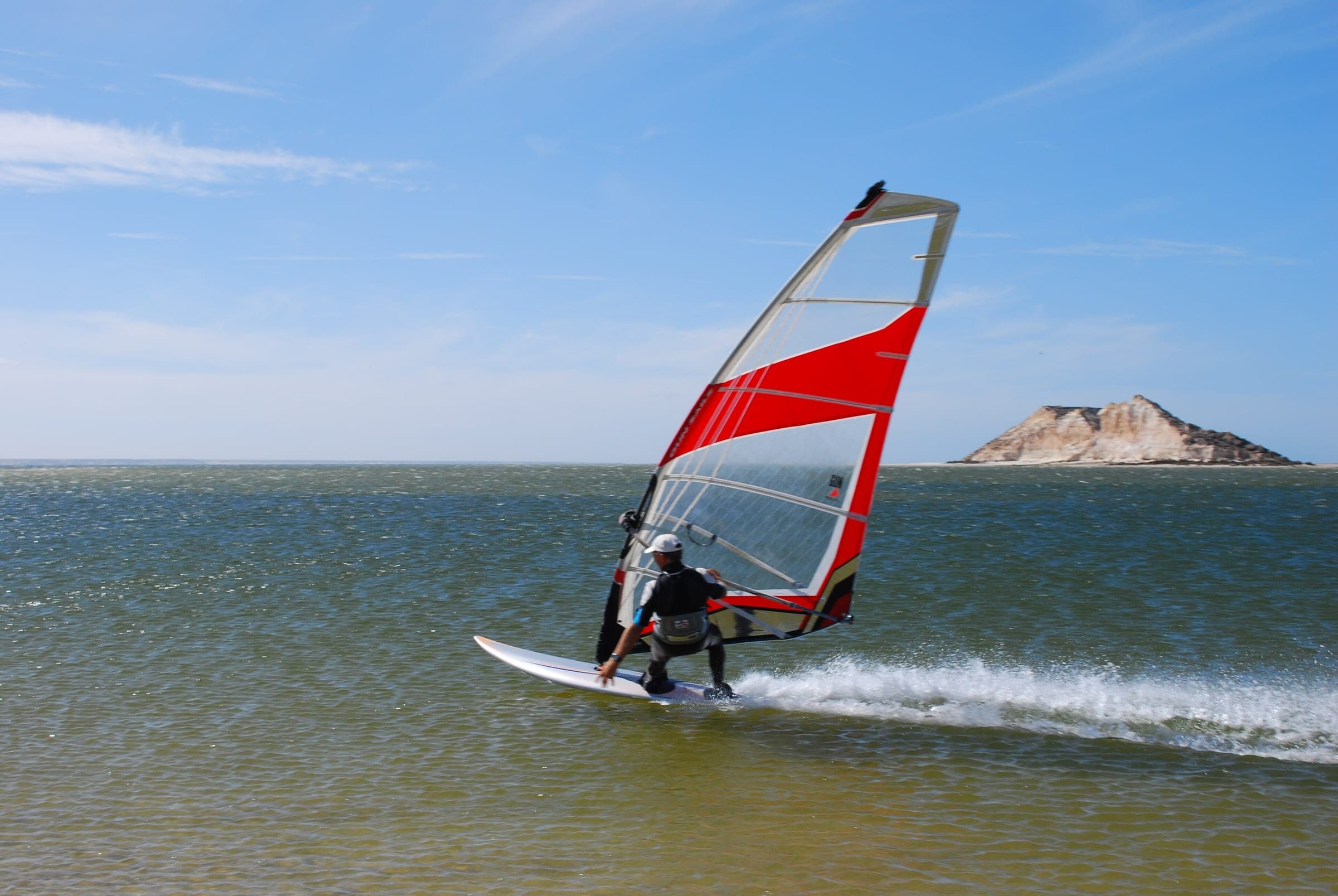 Planche à voile sur la lagune de Dakhla, l'île du Dragon en arrière-plan